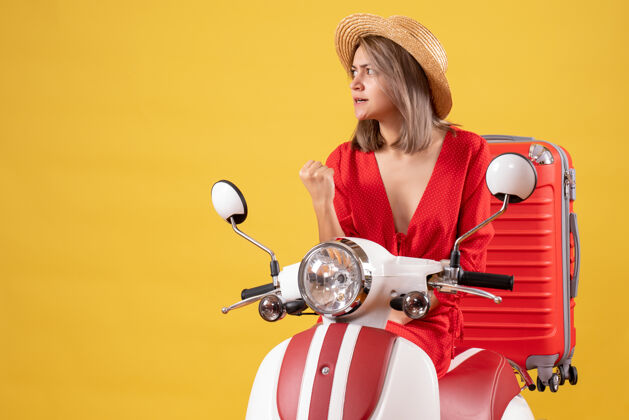 漂亮骑着轻便摩托车 带着红色手提箱的漂亮女孩的正视图轻便摩托车摩托车肖像