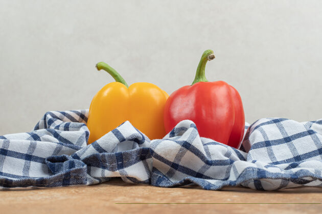 自然两个五颜六色的辣椒躺在桌布上团体胡椒美味