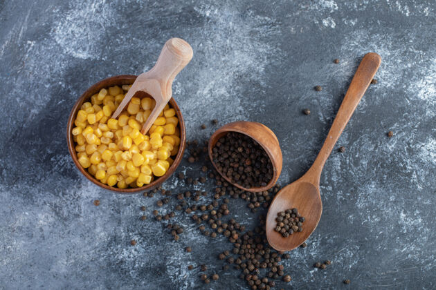 顶视图一碗甜玉米和谷物辣椒放在大理石上膳食草药谷物