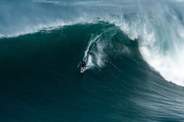 极限冲浪者骑在大西洋的海浪向海岸在纳扎尔 葡萄牙动作冲浪休息