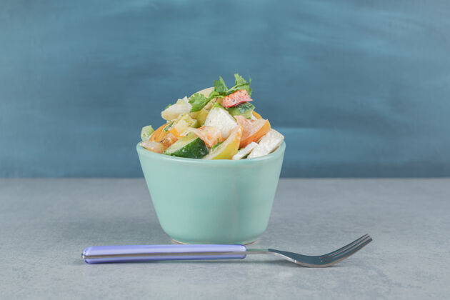 黄瓜蓝色杯子里的沙拉 混合切碎的蔬菜和水果晚餐食物盘子
