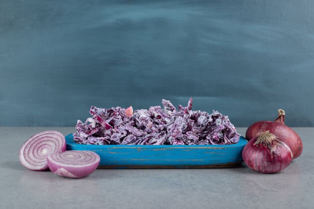 盘子切碎的紫洋葱和卷心菜沙拉放在水泥桌上的盘子里早午餐季节食物