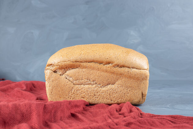 桌布红色桌布下一块面包放在大理石桌上美味可口面团
