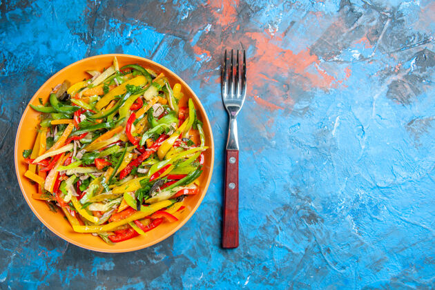 沙拉黑色表面上美味蔬菜沙拉的俯视图晚餐胡椒美味的蔬菜沙拉