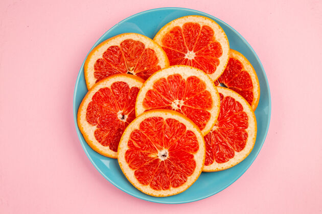 里面美味的葡萄柚水果片在粉红色表面盘子内俯视图健康切片水果