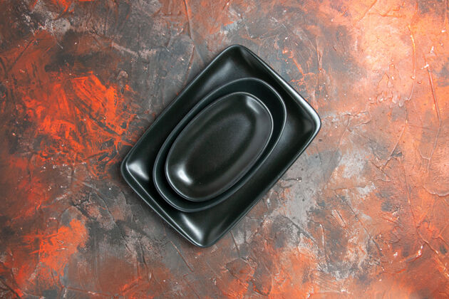 碟子黑色椭圆形和矩形盘片在深红色表面的俯视图椭圆形技术音乐