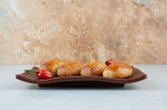 面包房一盘深色的玫瑰果甜饼饼干美味玫瑰果
