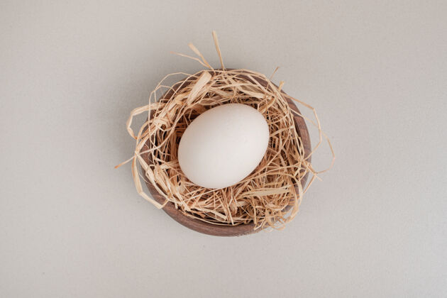 饮食木碗里放着新鲜的鸡蛋和干草家禽鸡蛋壳