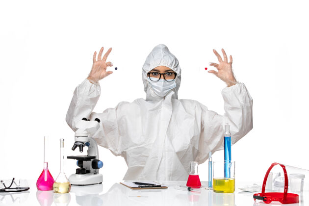 保护前视图穿着特殊防护服的女化学家拿着浅白色背景上的样本病毒化学covid大流行健康样品套装病毒