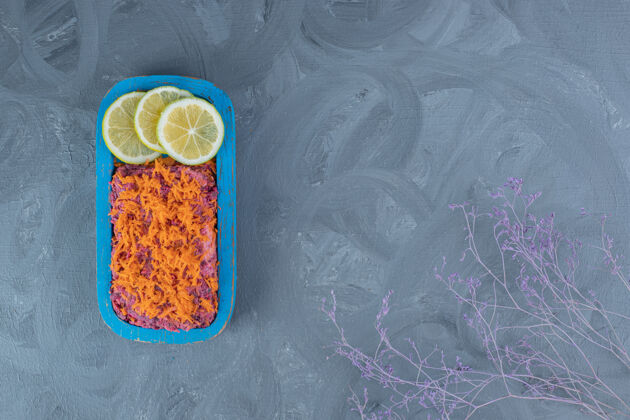 复制空间甜菜根和胡桃沙拉 上面放着胡萝卜 大理石桌上点缀着柠檬片切片复制空间柠檬