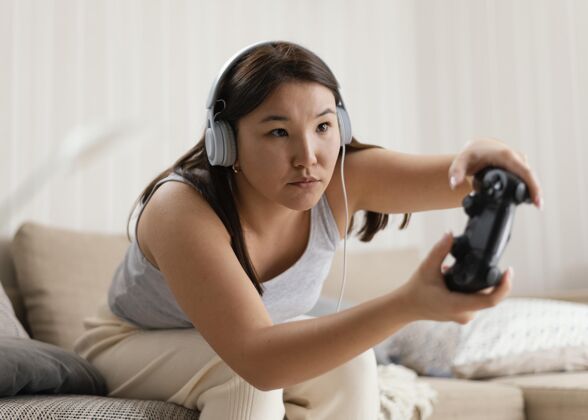 控制器中枪女人在家玩游戏中景室内视频游戏