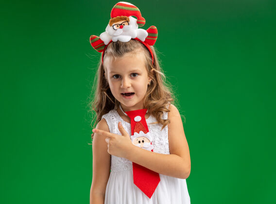 空间快乐的小女孩戴着圣诞发箍 在绿色背景上隔离一边系着领带复制绿色小