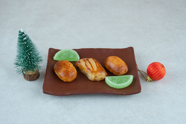大理石一盘深色甜点 上面有果酱和圣诞玩具糕点美味果冻