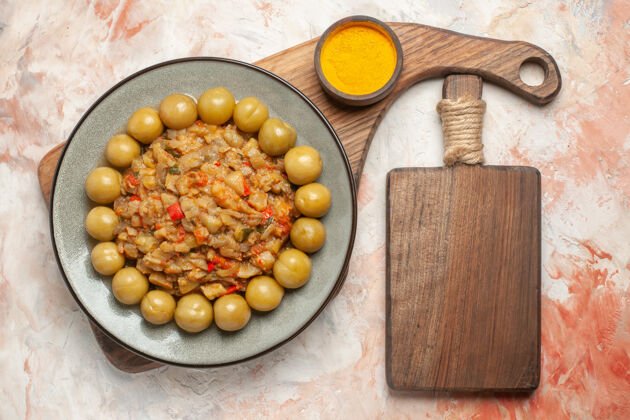 排骨烤茄子沙拉盘顶视图姜黄在碗里在木制的服务板一个砧板在裸体表面板食品种子