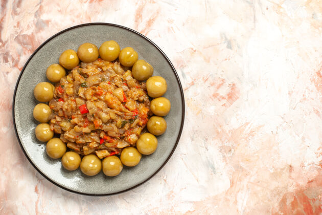 食品烤茄子沙拉和腌李子在裸体表面上的盘子俯视图裸肉果仁玉米