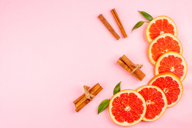 健康粉红色表面上美味的葡萄柚和多汁的水果片的俯视图装饰醇香多汁