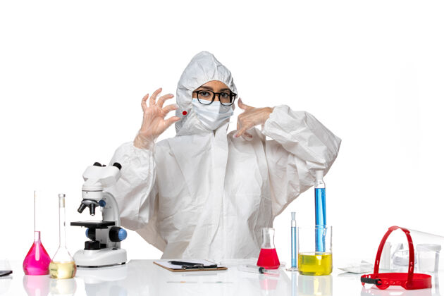 医学前视图穿着特殊防护服的女化学家拿着浅白色背景上的样本化学冠状病毒大流行医学实验室外套浅白色