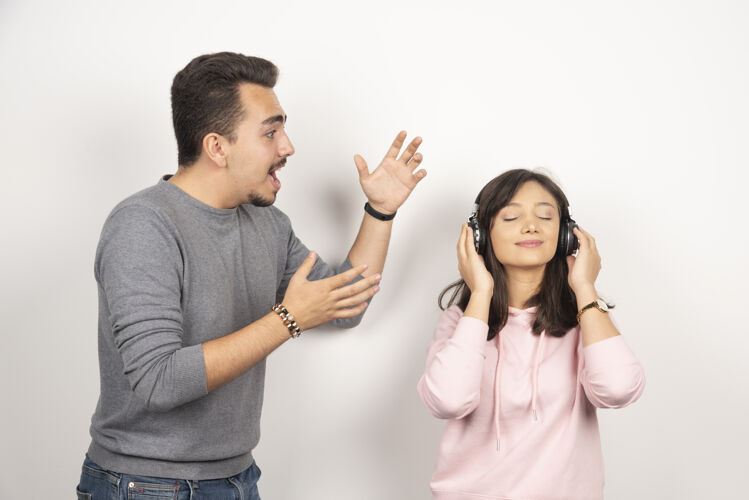 人年轻人对女人不断的吵闹感到生气耳机年轻人女人