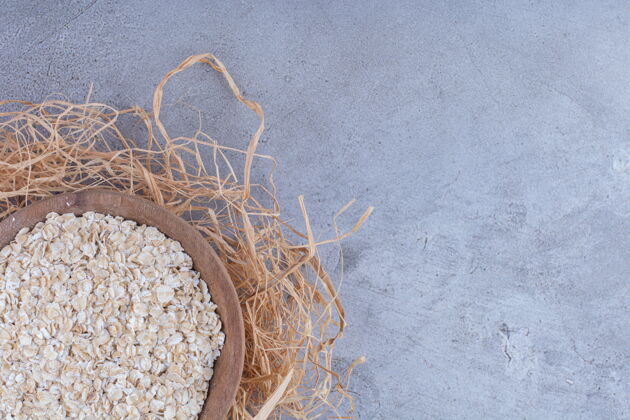 饮食一碗燕麦放在大理石表面的装饰稻草堆上面美味健康早餐