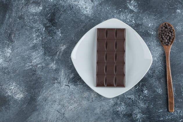 食物一块巧克力和巧克力碎片放在大理石表面桌布美食可可