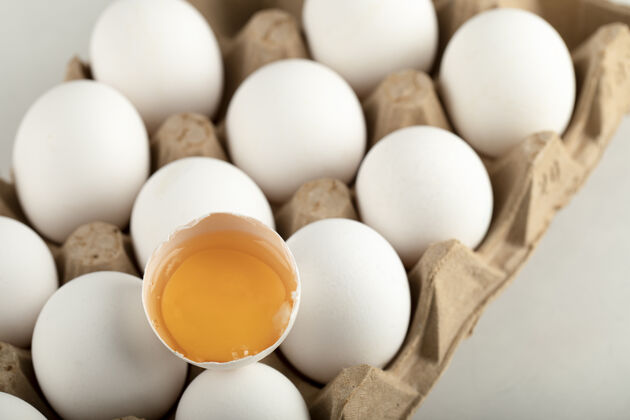 生的生鸡蛋放在蛋盒里 放在白色的表面上开放鸡蛋盒鸡蛋纸箱
