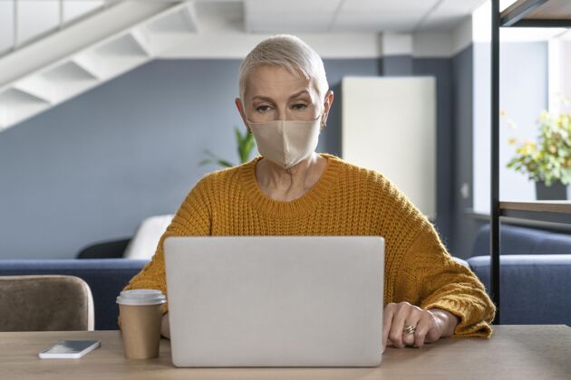 距离戴着医用面罩的女人在工作同事工作工作