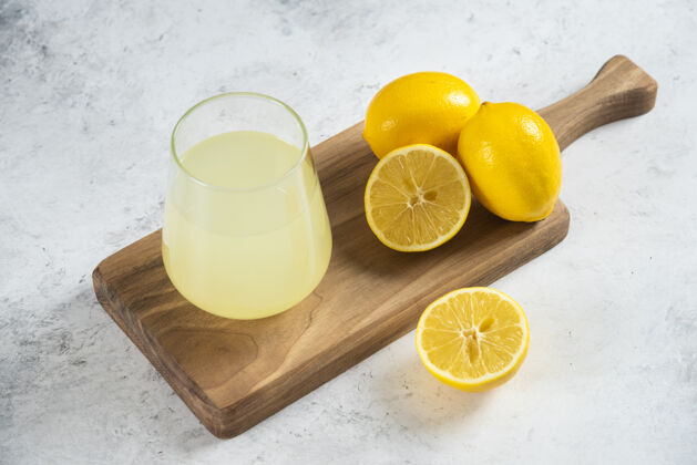 凉在木板上放一杯新鲜的柠檬汁餐桌柠檬水柑橘