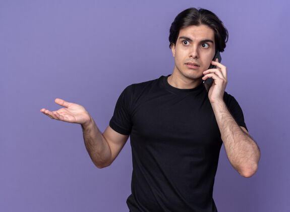 传迷茫的年轻帅哥穿着黑色t恤在电话里讲话 手被隔离在紫色的墙上帅哥迷茫手