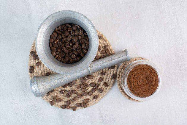 香味咖啡豆在研钵和杵与可可粉粉末豆子