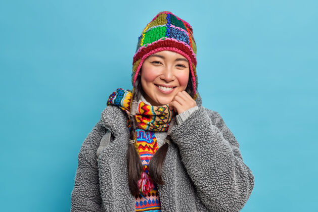 冬天快乐的亚洲女孩的画像 涂着胭脂的脸颊和牙齿的微笑微笑高兴头饰