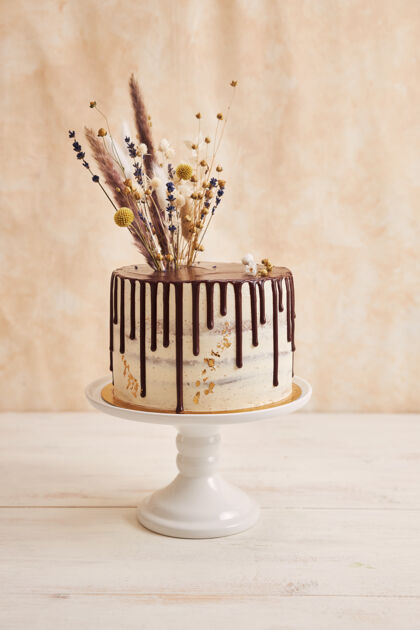 美食垂直拍摄美味波西米亚蛋糕与巧克力滴和鲜花上的黄金装饰小吃烘焙糖