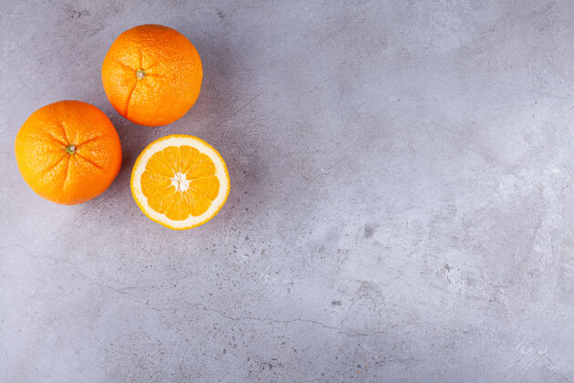 成熟整个和切片的橘子水果放在石头背景上橙子背景水果