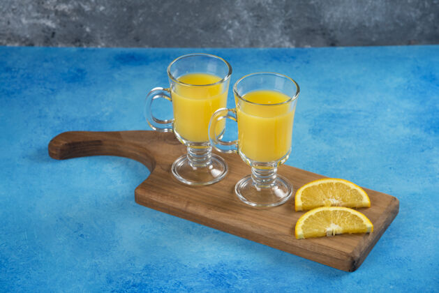橙子两杯美味的橙汁放在木板上水柑橘美味