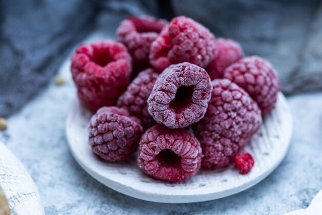 新鲜桌上盘子里冻树莓的特写镜头食物特写浆果