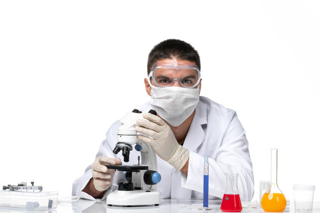 男医生前视图：男医生穿着白色医疗服 戴着面罩 在空白处使用显微镜面具实验室外套到期