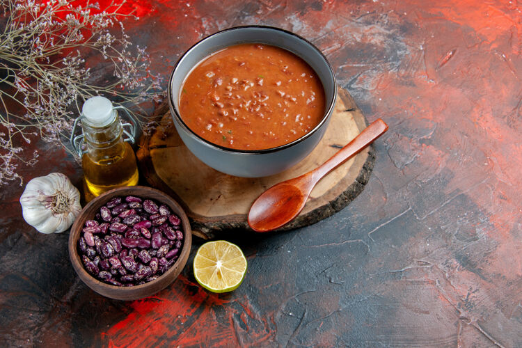容器侧视图番茄汤在一个蓝色的碗在一个木制托盘豆子油瓶上混合颜色的表饭汤壁板