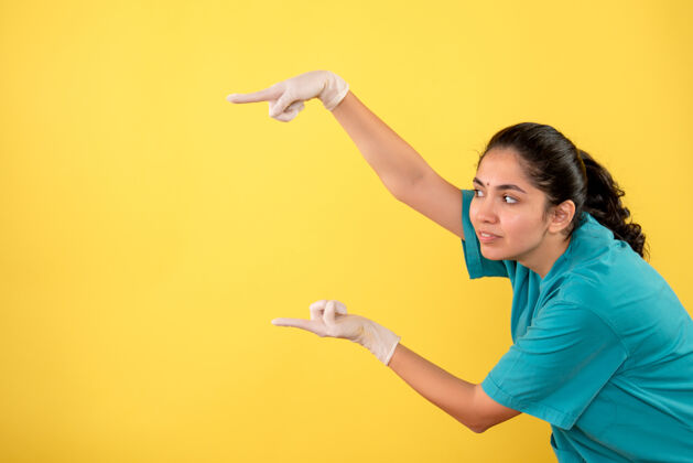 微笑正面图：女医生戴着乳胶手套 手指指向左边黄色人左边