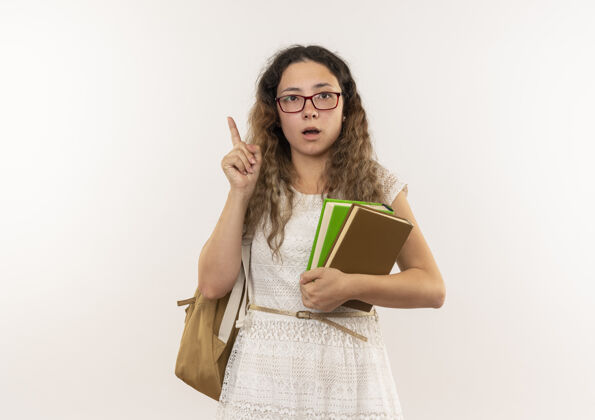 背年轻漂亮的女学生戴着眼镜 背着书包 举着手指孤立地站在白色的地板上手指举抱