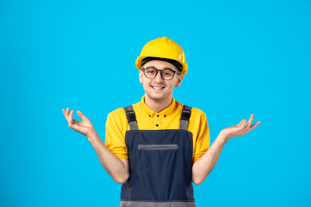 制服正面图：身着制服 头戴蓝色头盔 面带微笑的男工人头盔建筑工人帽子