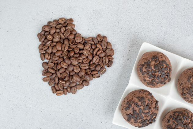 美味巧克力饼干和咖啡豆在白色的表面美味面包房糕点