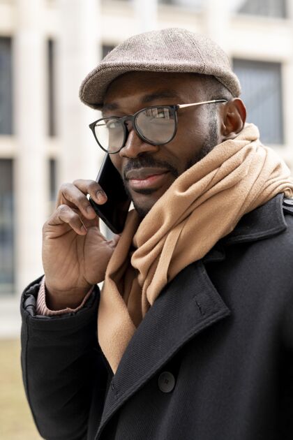帽子现代人拿着他的智能手机时尚男性垂直