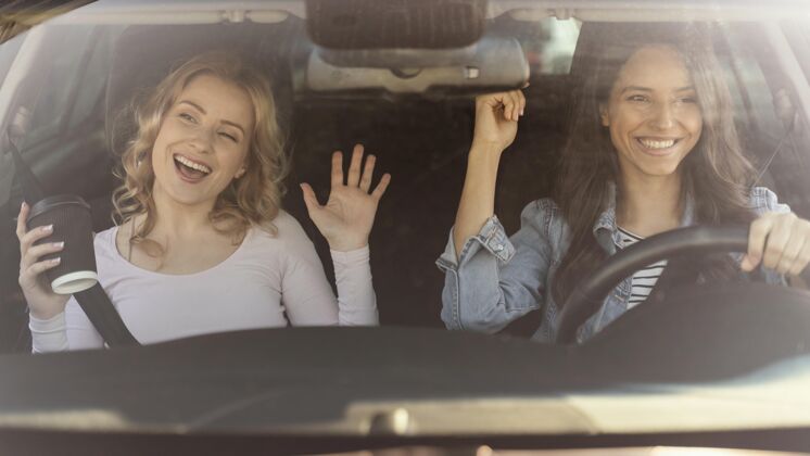 车女孩们在车里玩得很开心人车主年轻人