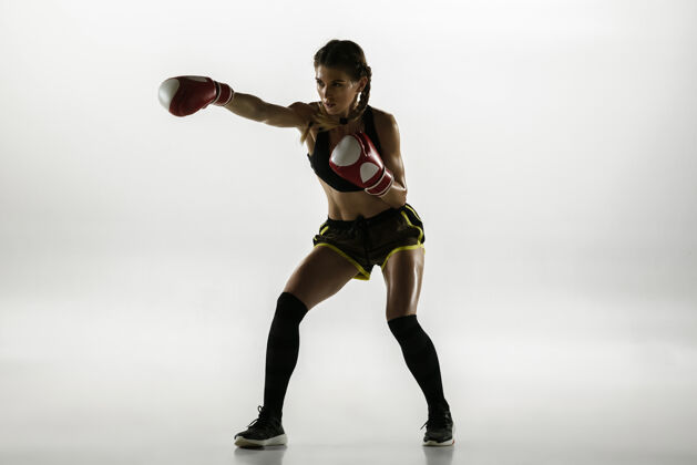 拳击手适合白人女子在运动装拳击隔离白墙新手女子高加索拳击手训练和练习的运动和行动运动 健康的生活方式 运动的概念训练拳击运动服