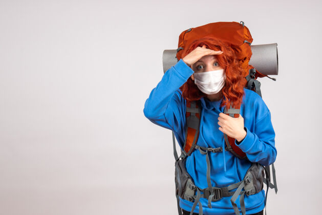 山戴着面具背着背包的女游客的正面图人女人年轻
