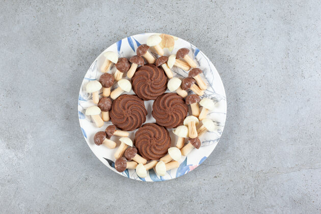 糕点在大理石背景的盘子上 饼干被巧克力蘑菇包围高质量的照片美味糖美味