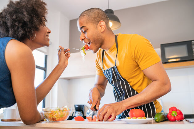 年轻一对年轻的拉丁夫妇在家厨房一起做饭的画像美食庆祝积极