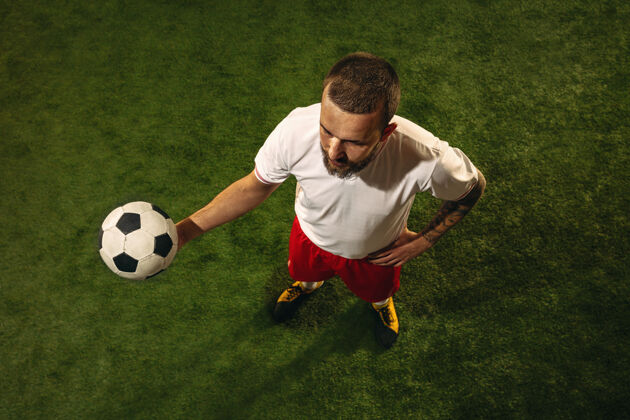 动作高加索足球或草地足球运动员的顶视图年轻男性运动模型训练 练习 踢球 进攻 接球运动概念 比赛 胜利球动作联赛