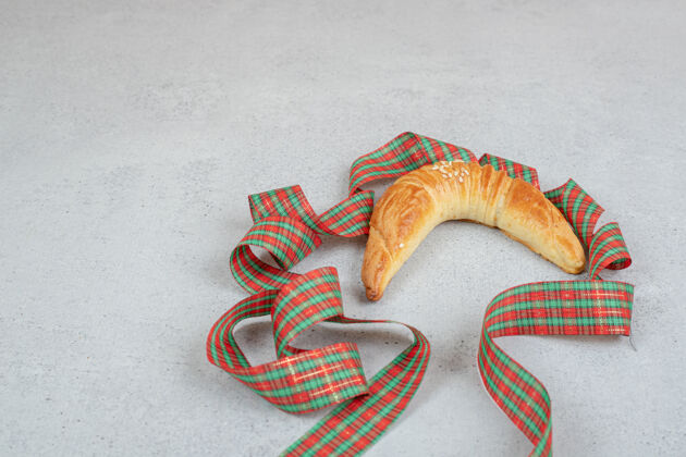 面包房新鲜甜美的羊角面包 白色表面有节日的蝴蝶结美味可口牛角面包