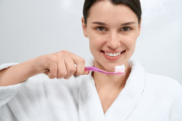 卫生微笑的女人在浴室里准备刷牙刷子牙齿皮肤