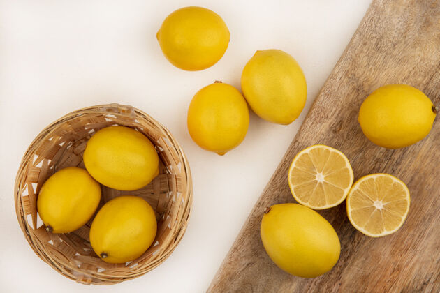 健康一桶新鲜柠檬的顶视图 柠檬被隔离在白色背景的木制厨房板上配料板视野
